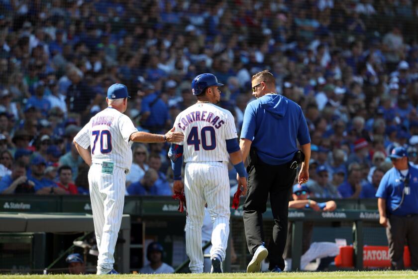 Chicago Cubs catcher Willson Contreras (40) leaves with a trainer after flying out in the seventh inning Saturday, Aug. 3, 2019 at Wrigley Field. (Brian Cassella/Chicago Tribune)