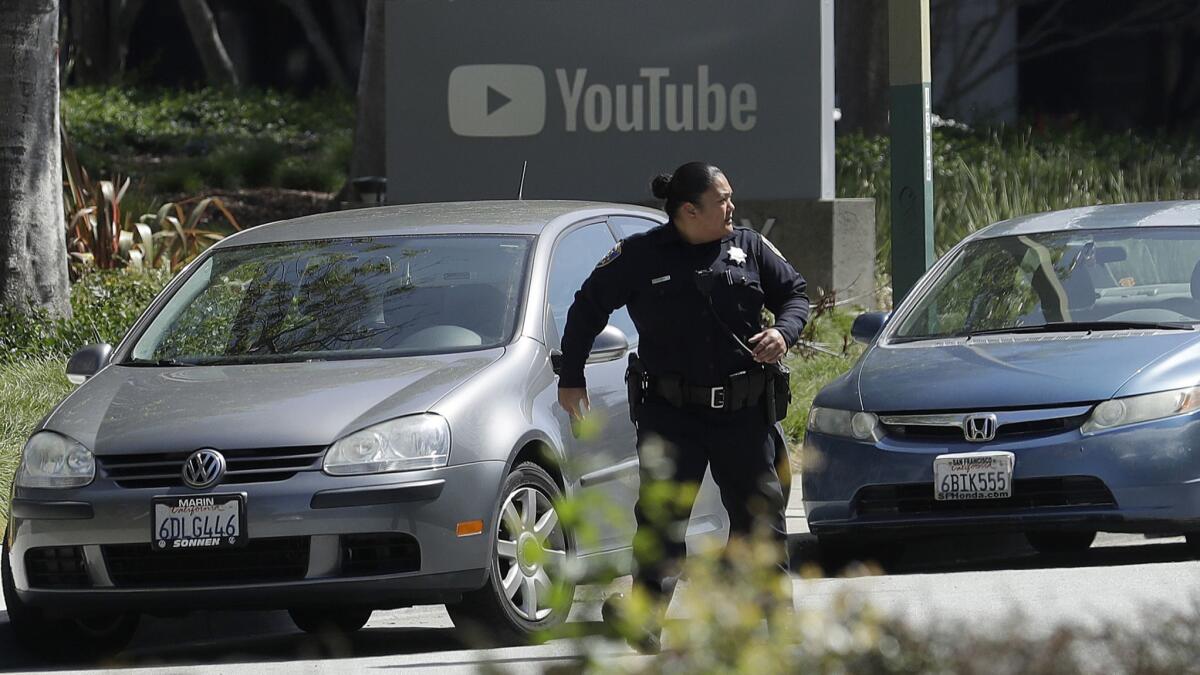 An officer runs past a YouTube sign near the company's complex in San Bruno, Calif., on Tuesday.