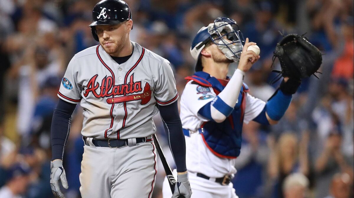 Atlanta Braves' Freddie Freeman strikes out to end the game in a 3-0 loss to the Dodgers as catcher Yasmani Grandal celebrates.