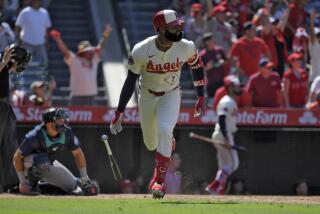 Los Angeles Angels' Jo Adell, right, heads to first for a three-run home run as Seattle Mariners.