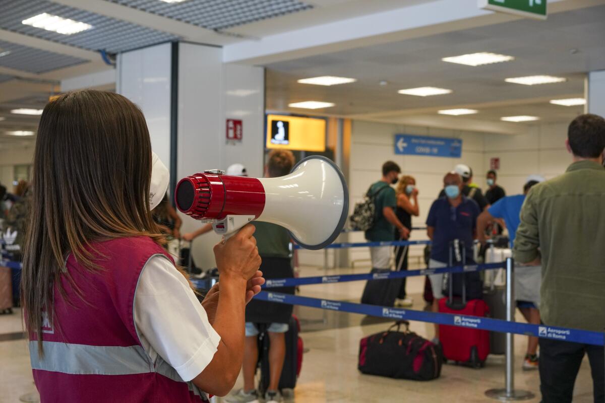 Passengers arriving in Rome from four Mediterranean countries receive instructions by airport staff
