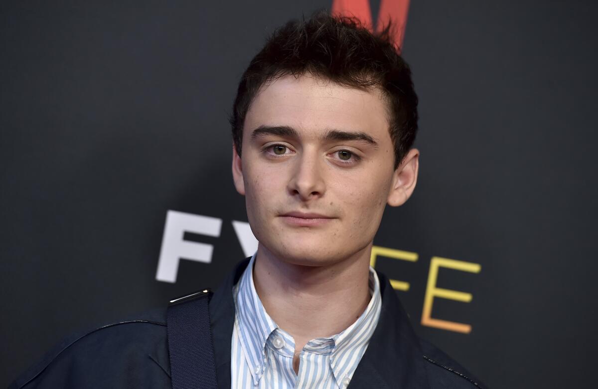 A young man with a blue and white shirt and dark blazer 