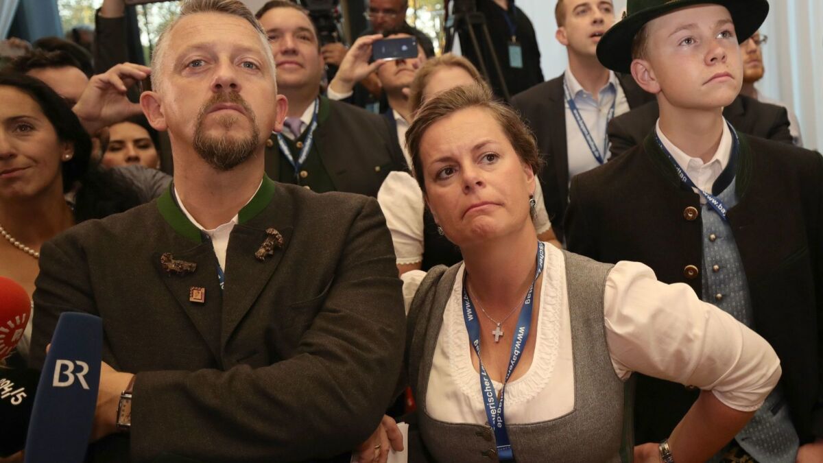 Supporters of the Christian Social Union react after first exit polls were announced on public television at the Bavarian regional government building Sunday.