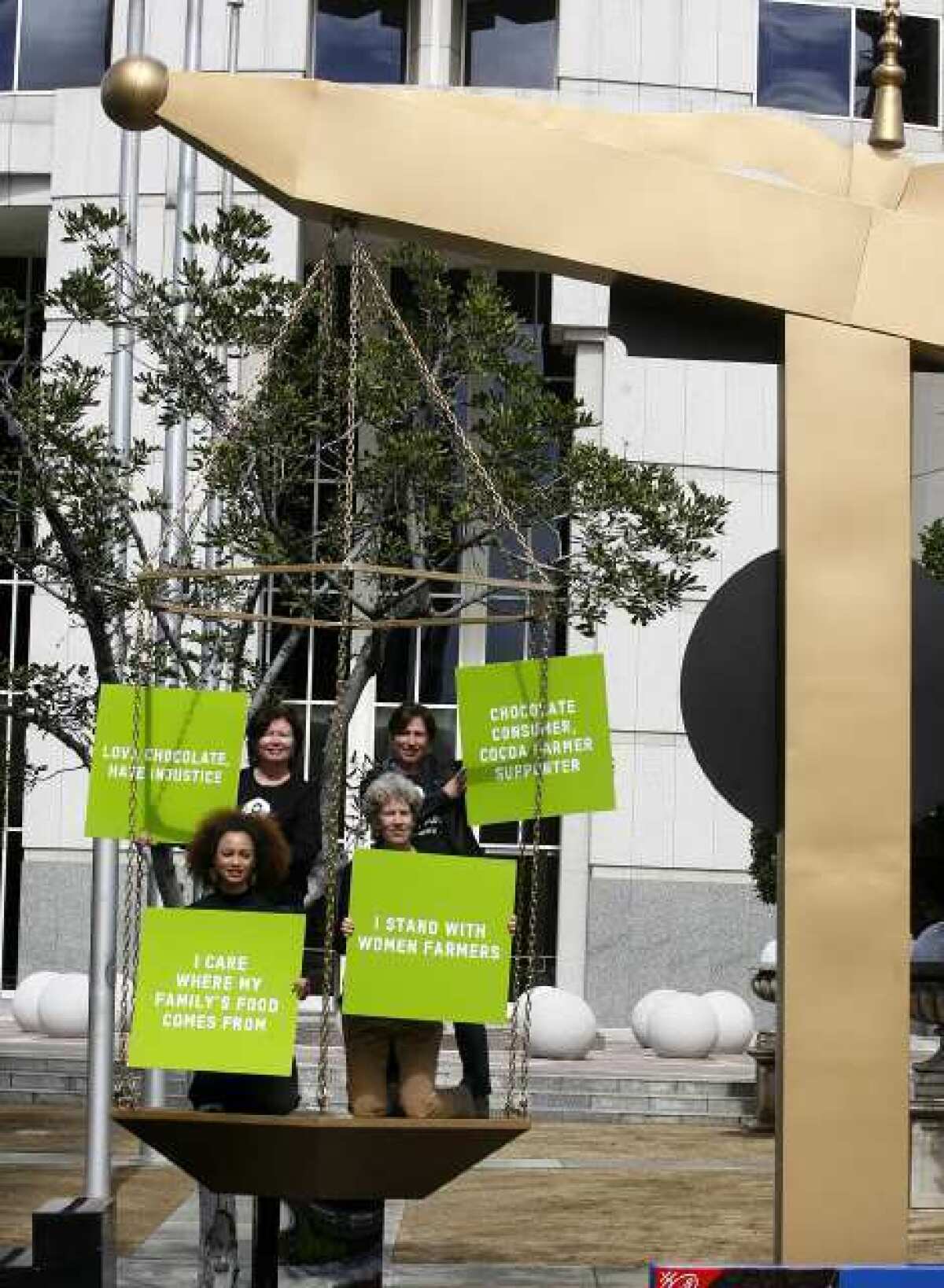Ramona Wright of Los Angeles, along with Judy Beals, Liz Carty and Irit Tamir of Boston, protest in front of the Nestle headquarters in Glendale. The Oxfam America protesters set up a giant scale to bring attention to the unfair treatment of women cocoa workers worldwide.
