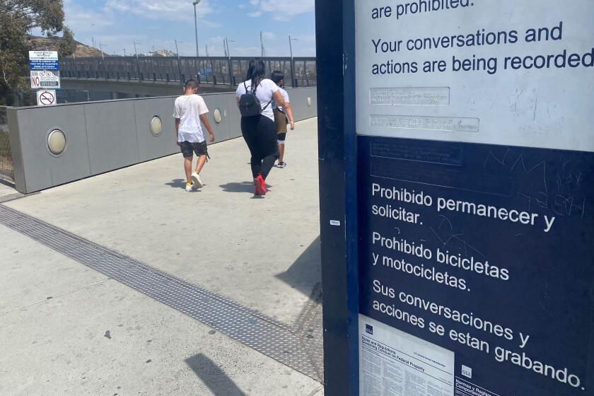 A sign on the pedestrian bridge at San Ysidro warns border crossings that they are being recorded.
