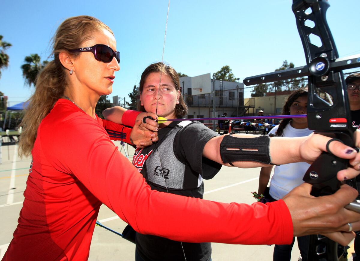 Dalar Karimian, 17, gets archery technique advice from U.S. Olympic archer Khatuna Lorig at Glendale High School on Tuesday, April 29, 2014. Lorig came to the archery program for the day at Glendale High School to help them develop their technique.