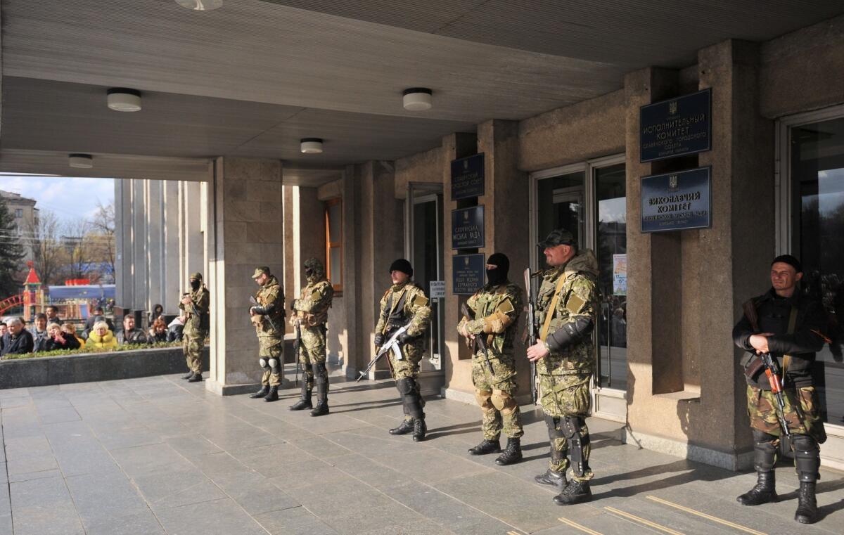 Armed pro-Russia militants stand guard outside the regional administration building in the eastern Ukrainian city of Slavyansk on Monday. Local police reportedly failed to support the Ukrainian government's ultimatum to pro-Kremlin militias to lay down their weapons, and the gunmen have gone on to seize more facilities in eastern Ukraine.