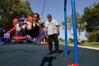 Bill Bradley pushes his grandson Kason Smart, 4, on a swing at Holly Park