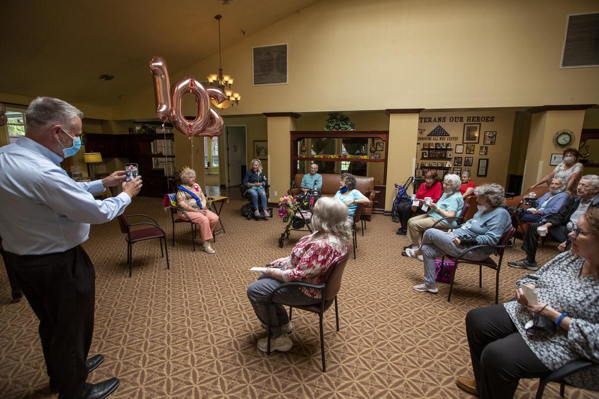 David Kuzmiak, left, and other residents of Carmel Village in Fountain Valley, sing happy birthday to Dorothy Powell.