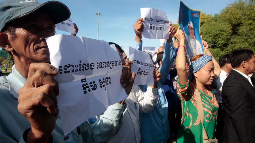 Supporters of the opposition Cambodia National Rescue Party hold up a portrait of the party leader, Kem Sokha, and signs that read "Free Kem Sokha" during a rally near an appeals court in Phnom Penh, Cambodia, on Sept. 26.