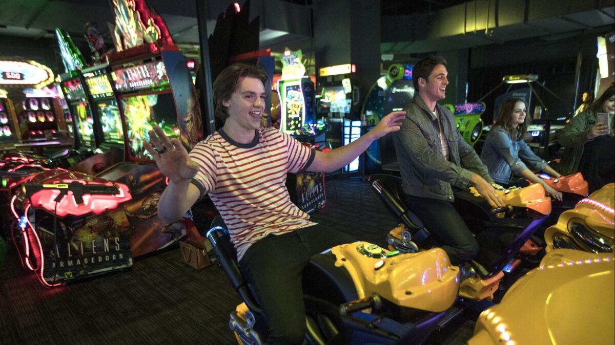  Joel Courtney, Jacob Elordi and Joey King of "The Kissing Booth" try out a motorcycle racing game at Dave & Busters in 2018.