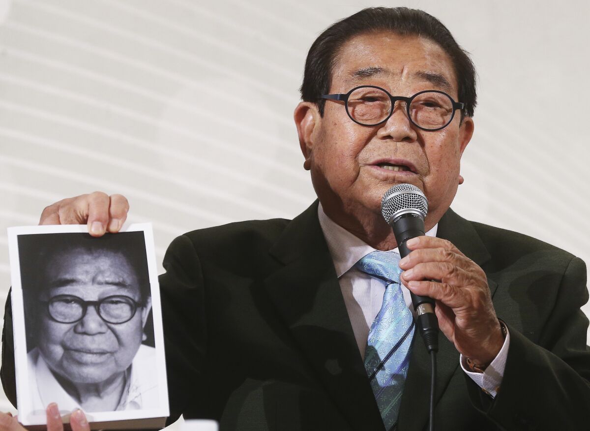 Song Hae, a South Korean TV presenter speaks as he holding his book in Seoul, South Korea, April 30, 2015. Song, who was beloved for decades as the warm-humored emcee of a nationally televised singing contest, has died at the age of 95. (Yonhap via AP)