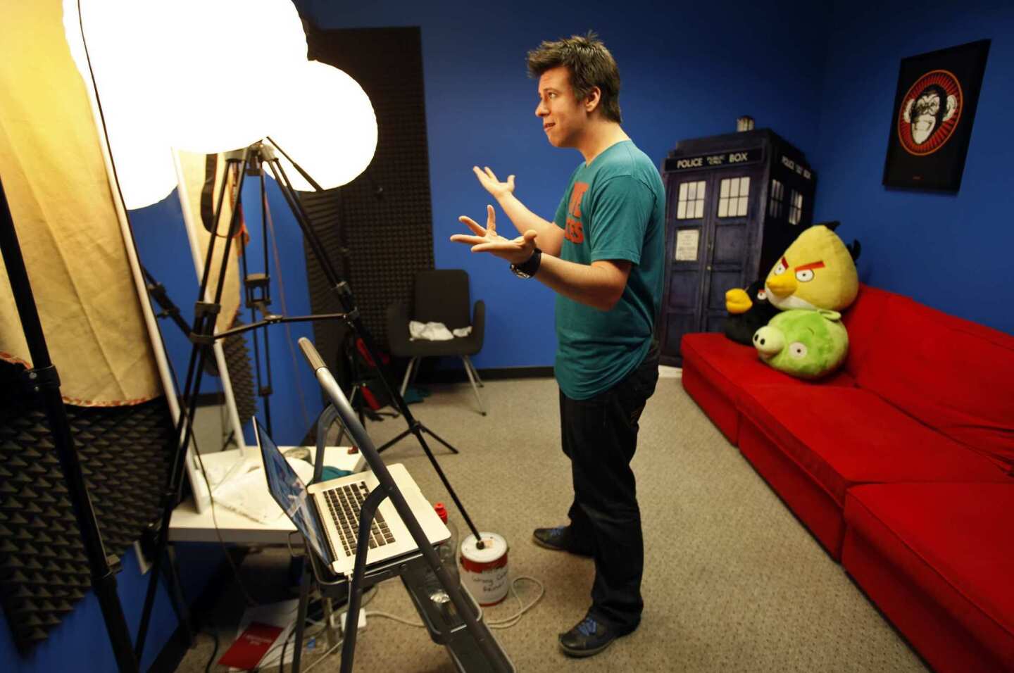 Philip DeFranco delivers his lines to his camera during a run-through Aug. 21 in the simple studio of his Woodland Hills production offices where he records his show as host of the "The Philip DeFranco Show," a news program on YouTube about news and pop culture. The show rivals Jon Stewart's "The Daily Show" in audience size. As the news anchor, DeFranco wears T-shirts instead of the standard-issue suit-and-tie, and the anchor desk has been replaced with a red futon decorated with stuffed characters.