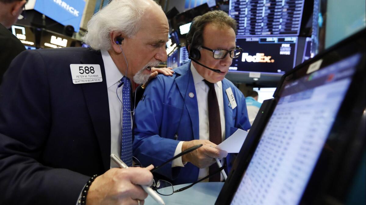 Traders Peter Tuchman, left, and Sal Suarino work on the floor of the New York Stock Exchange on Wednesday.