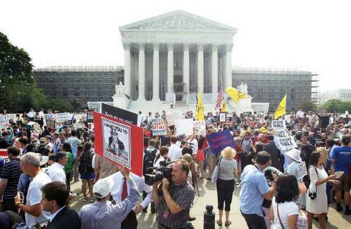 Supporters and foes of President Obama's healthcare program gather in front of the U.S. Supreme Court last month to find out the high court's ruling.