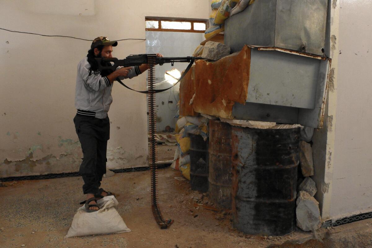 A rebel fighter with the Free Syrian Army holds a front-line position behind a barricade in the northern city of Aleppo on Oct. 1.