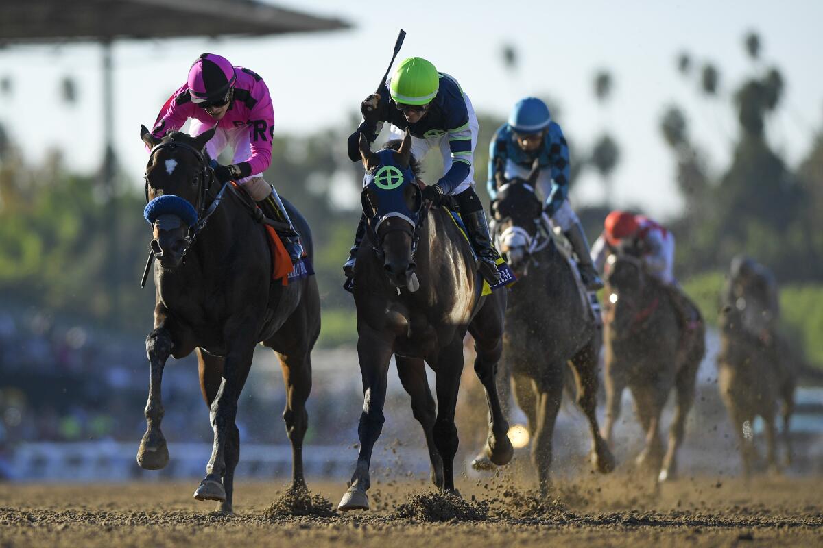 Flavien Prat celebrates after riding Storm the Court, right, to victory over Anneau D'or, left, in the Breeders' Cup Juvenile at Santa Anita on Friday.