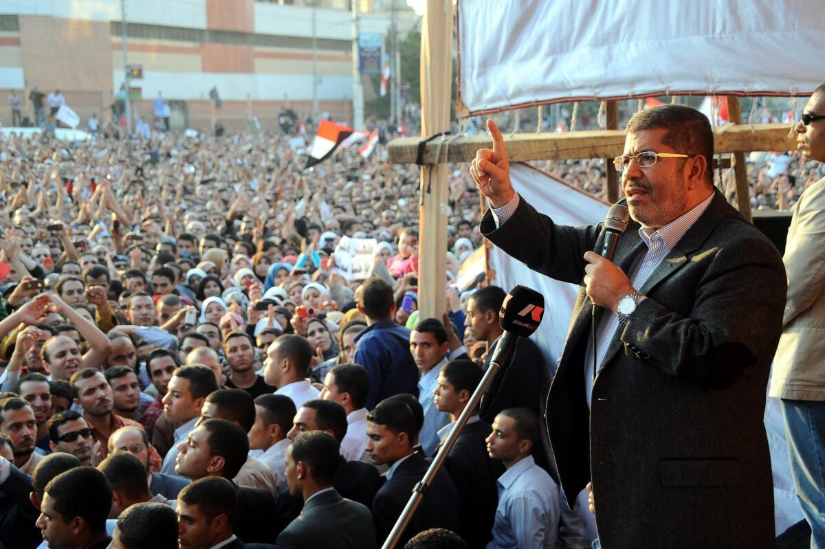 Egyptian President Mohamed Morsi delivers a speech to supporters next to the Presidential Palace in Cairo.