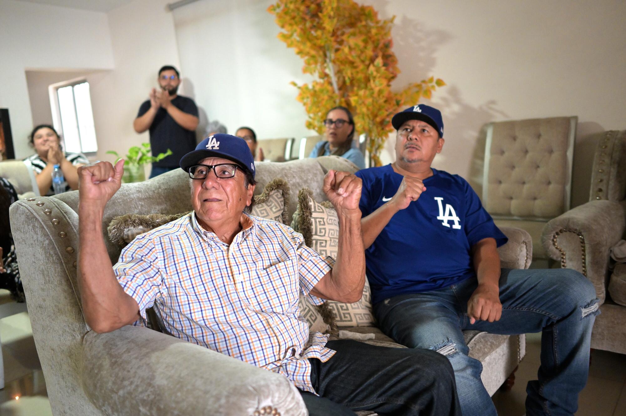 Grandfather Julián, left, and father Carlos watch Julio Urías pitch Aug. 28 against the Miami Marlins.