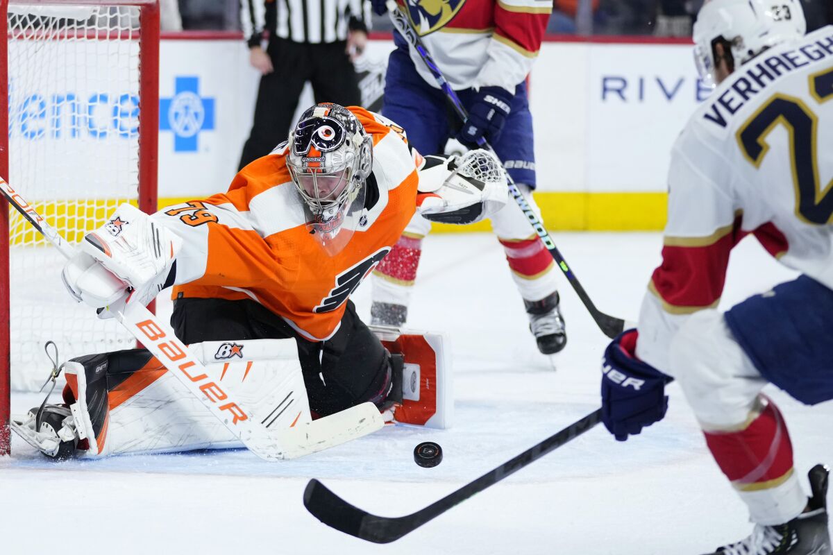 Philadelphia Flyers' Carter Hart, left, blocks a shot by Florida Panthers' Carter Verhaeghe during the third period of an NHL hockey game, Tuesday, March 21, 2023, in Philadelphia. (AP Photo/Matt Slocum)