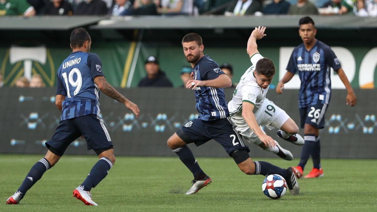 Portland Timbers' Tomas Conechny (19) is knocked off the ball by Galaxy midfielder Perry Kitchen (2) during a U.S. Open Cup soccer match in Portland, Ore. on Wednesday.