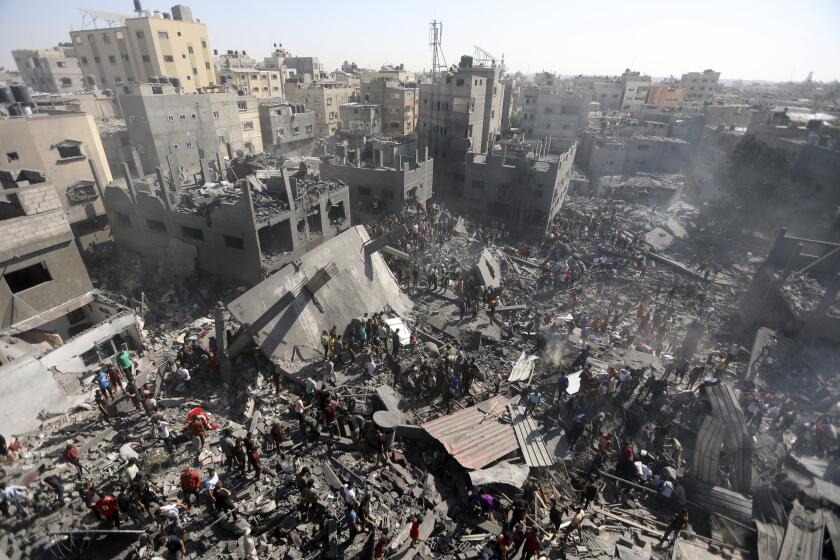 Palestinos revisan los restos de edificios derruidos tras ataques aéreos israelíes en la localidad de Khan Younis, en el sur de la Franja de Gaza, el jueves 26 de octubre de 2023. (AP Foto/Mohammed Dahman)