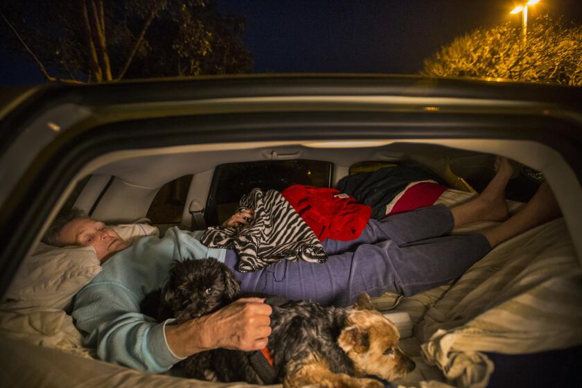 After the Carlsbad Senior Center closed for the night, Edye Russell, 79, tucks into the back of her car on an air mattress to sleep with her two "children" dogs Chloe, right, and Tippy. (Allen J. Schaben / Los Angeles Times)