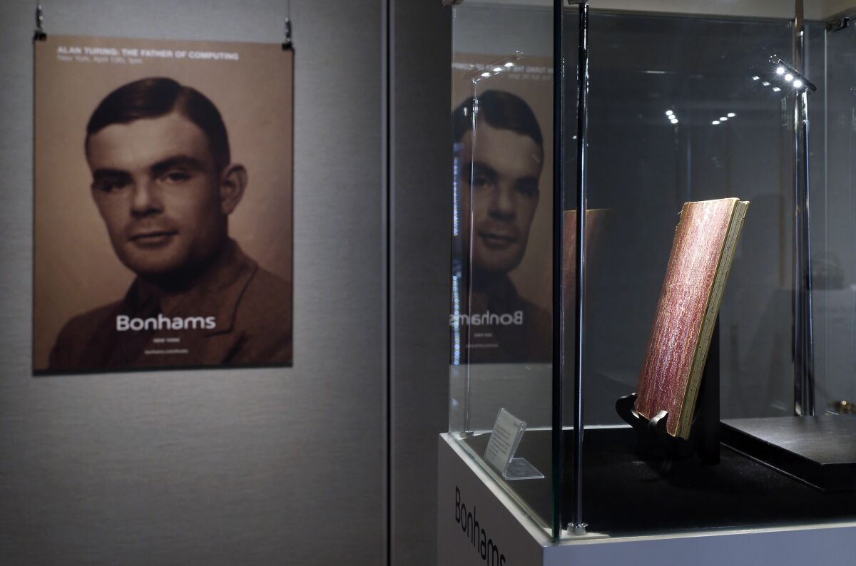 Portrait of Alan Turing and one of his notebooks on display