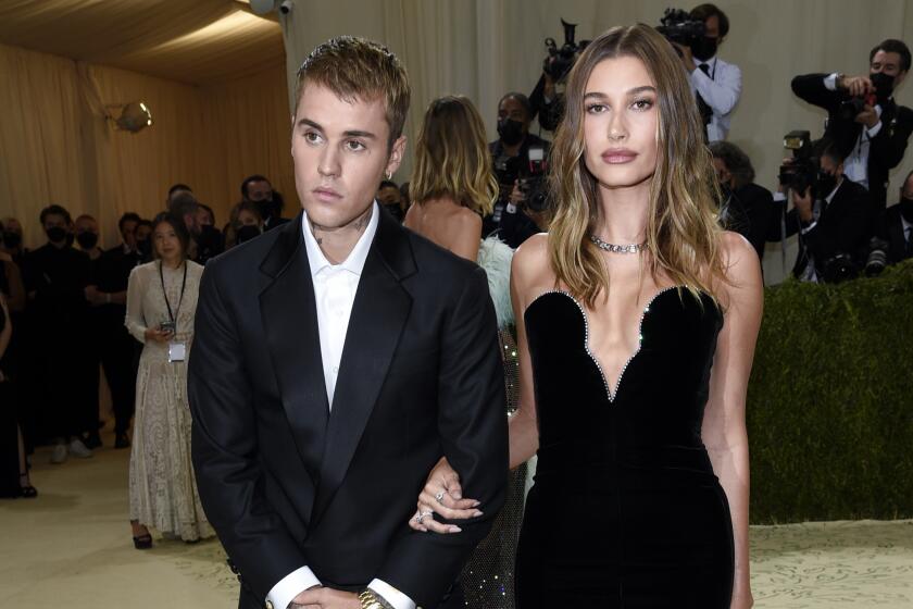 Justin Bieber and Hailey Bieber in black formal wear posing next to each other at the Met Gala