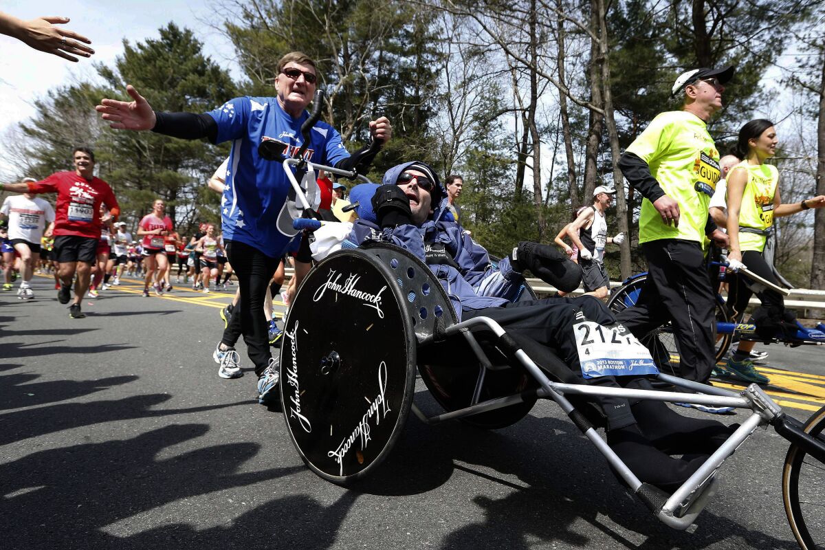 Rick Hoyt, center, is pushed by his father, Dick, along the Boston Marathon course on April 15, 2013.