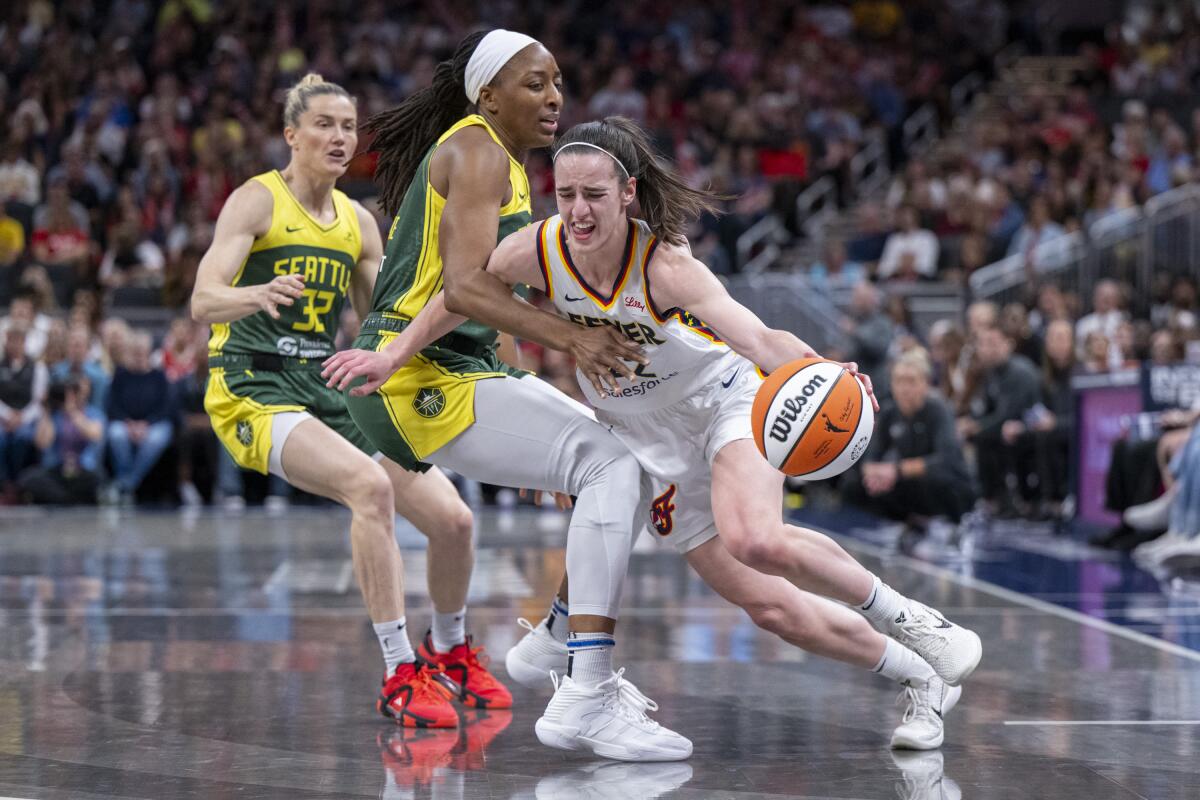 Indiana Fever guard Caitlin Clark drives against Seattle Storm forward Nneka Ogwumike.