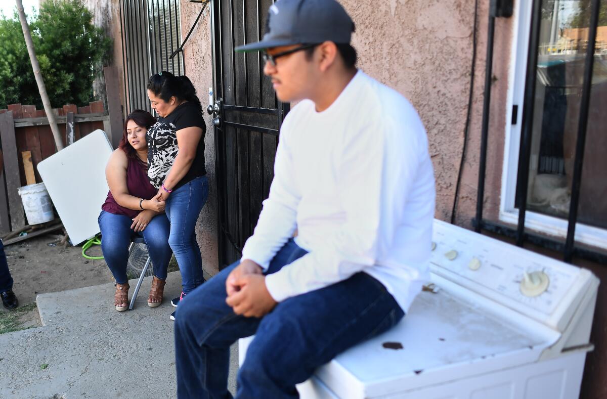 Jose Bello's family hangs out in the front yard including from left, girlfriend Edith Mata, mother Araceli Reyes and brother Ulises Roboero.