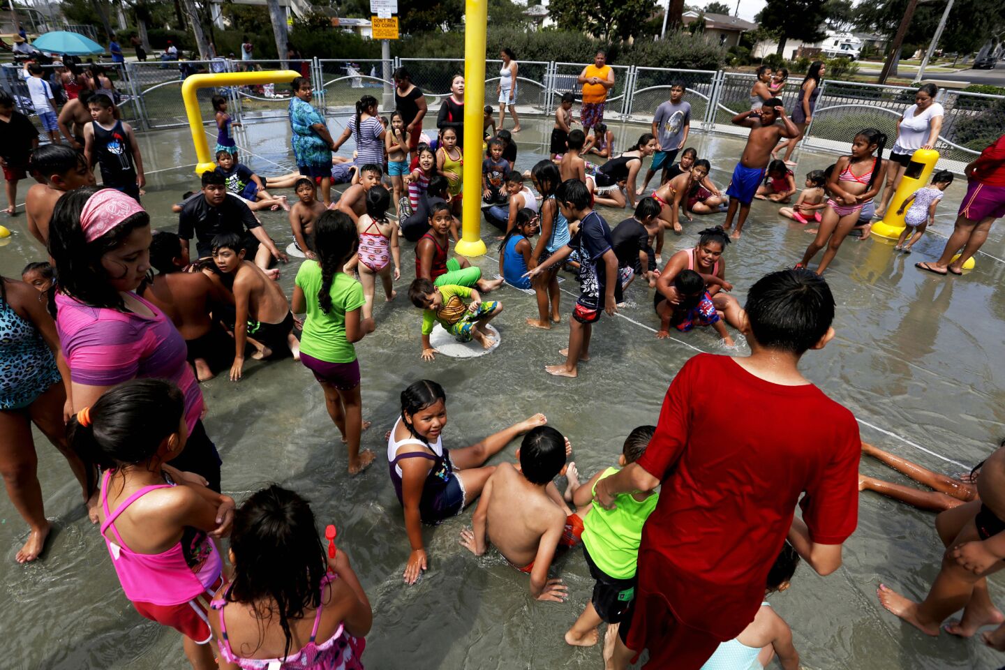 The crowd waits for the water to return after a brief break in the spray pool at Fullerton's Lemon Park.