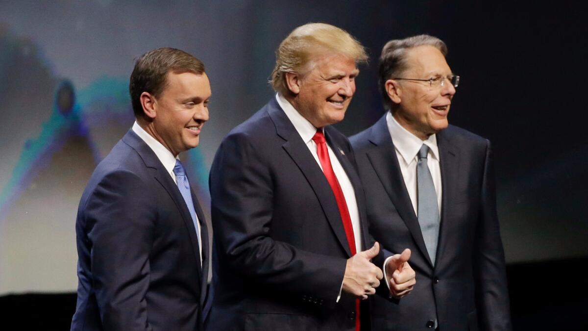 Republican presidential candidate Donald Trump is introduced by National Rifle Association executive director Chris W. Cox, left, and NRA executive vice president Wayne LaPierre as he takes the stage to speak at the NRA convention in Louisville, Ky. on May 20.
