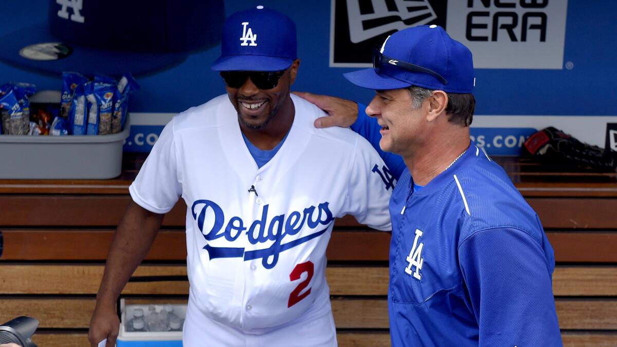 Acting Dodgers Manager Jimmy Rollins, left, wears the uniform of former manager Tom Lasorda as he poses with Don Mattingly before the regular-season finale on Sunday.
