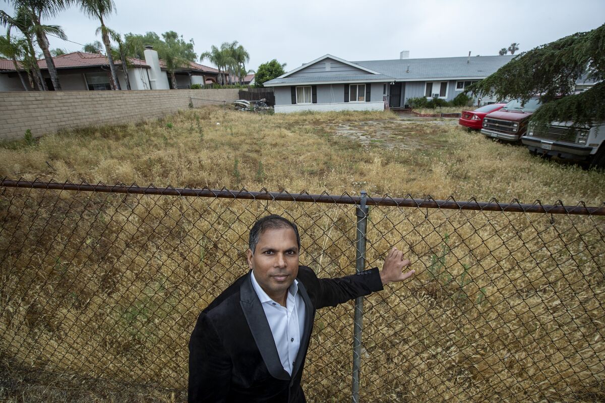 Akhilesh Jha at a one-acre lot with a chain link fence