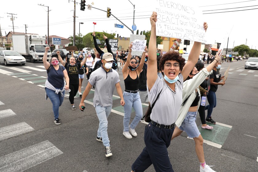 Demonstrators including Dillon Redd, 20, front, march in the streets in a peaceful protest in Cerritos on Monday.