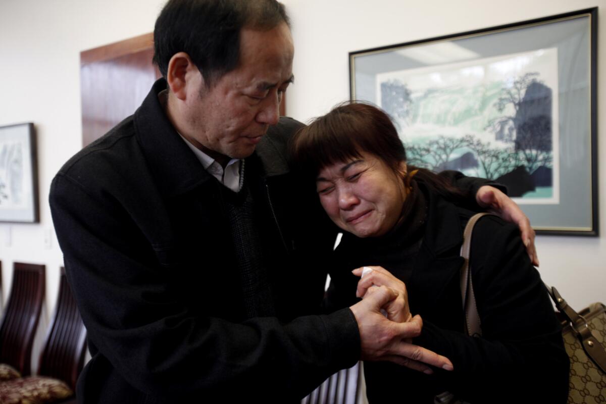 Xiyong Wu, left, tries to comfort his wife Meinan Yin, right, following a news conference in Rosemead. Their daughter, Ying Wu, was one of two USC students killed in April 2012.