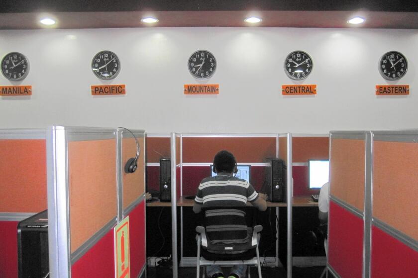 Workers at Visaya Knowledge Process' call center in central Manila sit shoulder to shoulder as they speak with people in the United States. A tote board on one wall tracks in-coming calls as well as metrics like the time spent with each customer.