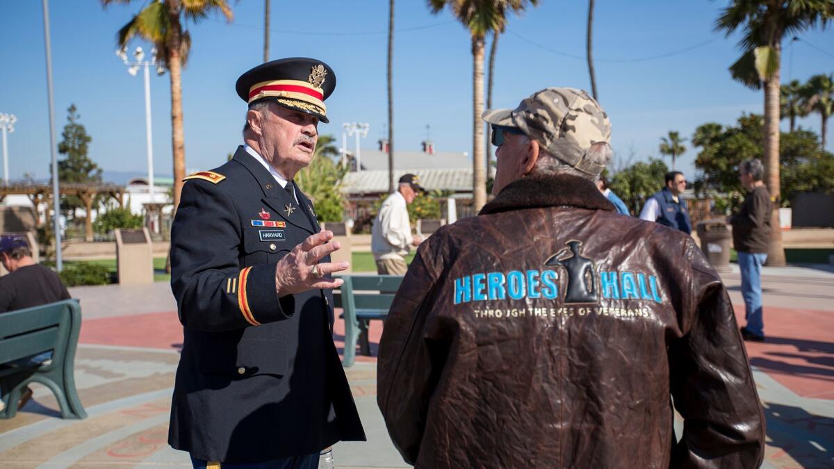 Al Harvard, left, talks with Nick Berardino during the celebration of the first anniversary of Heroes Hall veterans museum at the OC Fair & Event Center on Thursday.