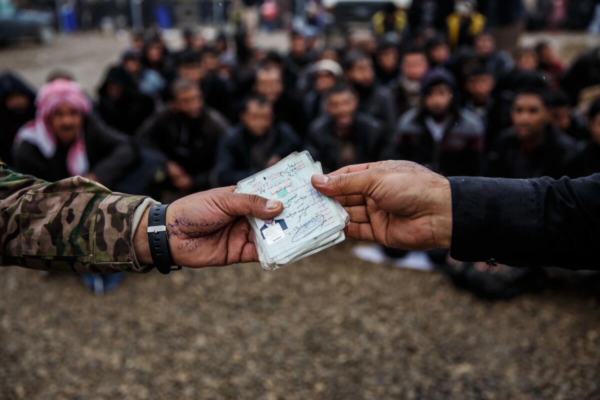 Men arriving at the Hammam Alil camp must hand over their identifications to security for checking.