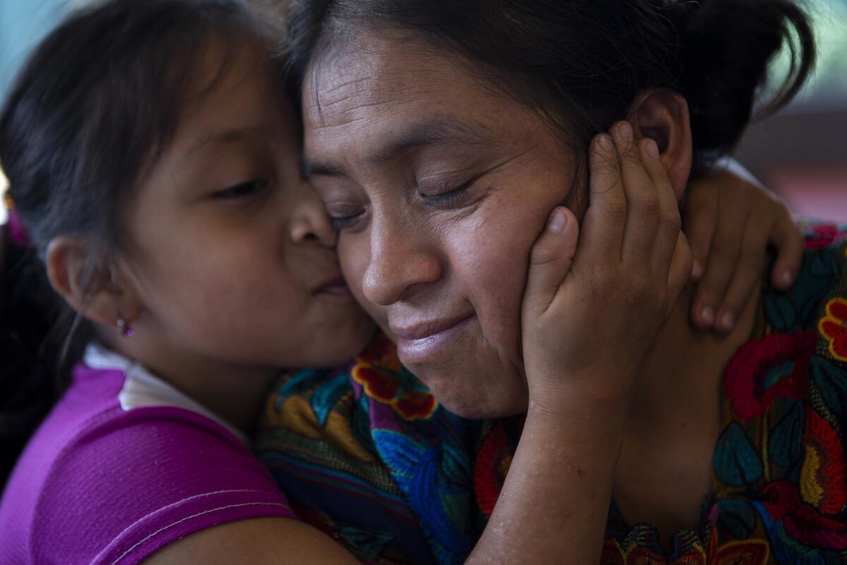 Astrid Cardona kisses her mother Ufemia Tomas, the mother of survivor Yenifer Yulisa Cardona Tomas, during an interview in Guatemala City, Monday, July 4, 2022. Yenifer is one of the survivors of the more than 50 migrants who were found dead inside a tractor-trailer near San Antonio, Texas. (AP Photo/Oliver de Ros)