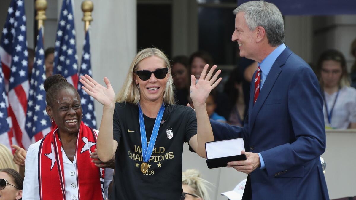 Allie Long of the U.S. women’s national soccer team receives the key to New York City from Chirlane McCray and Mayor Bill de Blasio during a ceremony Wednesday.