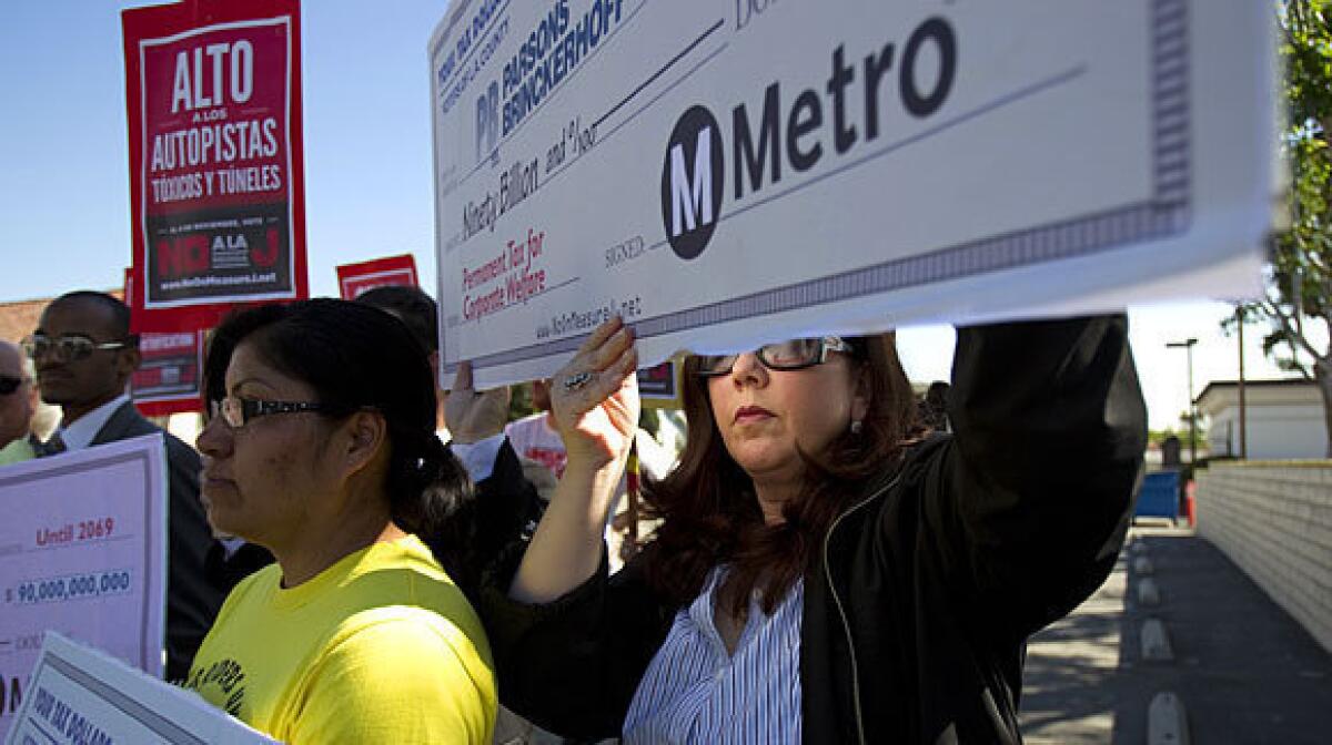 Lisa Korbatov, right, of Beverly Hills joins Rosa Miranda of the Bus Riders Union holding blank checks highlighting Measure J's corporate sponsors and beneficiaries during an October rally.