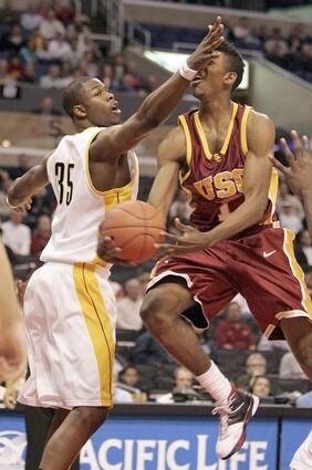 Cal's DeVon Hardin hits USC's Nick Young in the face as Young scoops in a shot.