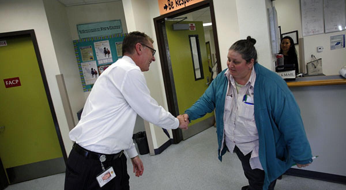 Los Angeles Unified School District superintendent John Deasy, left, shakes hands with senior office tech Bonnie Sugerman at John H. Liechty Middle School.