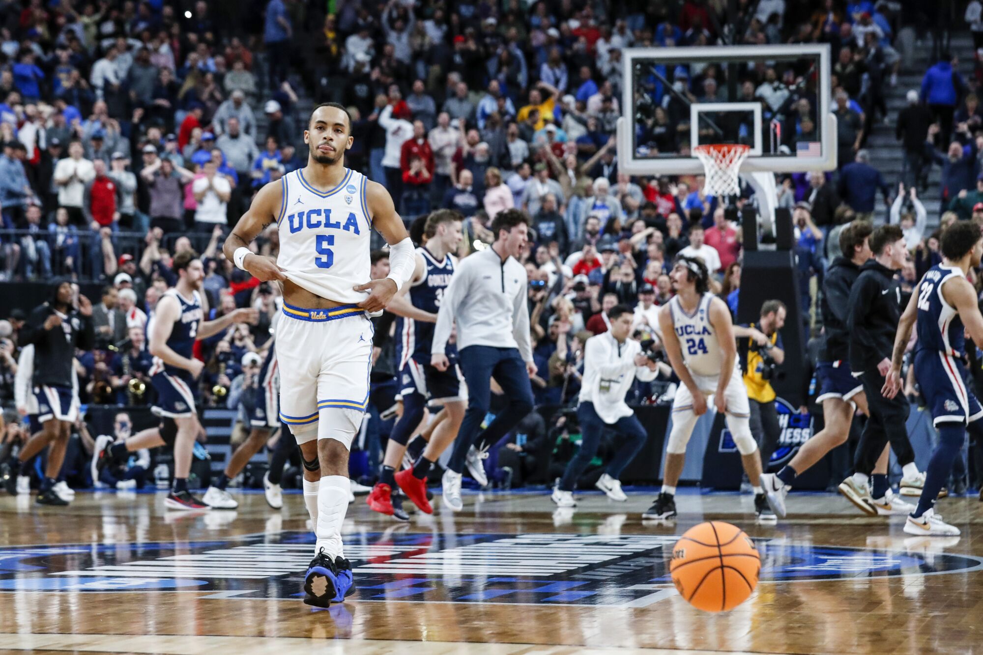 UCLA guard Amari Bailey (5) walks away from Gonzaga's celebration.