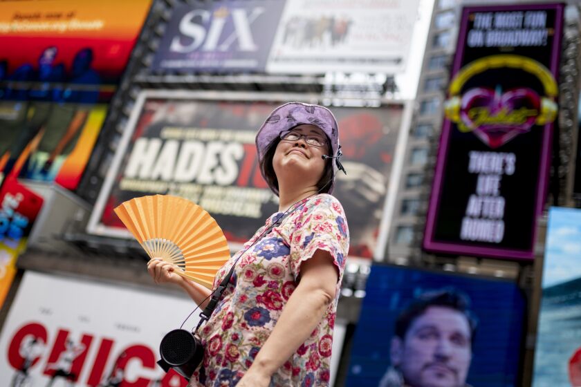 En esta imagen de archivo, una guía turística se abanica mientras trabaja en Times Square en un día de calor, el 27 de julio de 2023, en Nueva York. (AP Foto/John Minchillo, archivo)