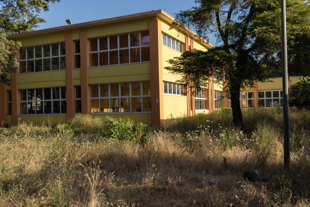 Grass grows last summer in the courtyard of a Taranto school that was shut down due to pollutants. After a cleanup, the school opened in September.
