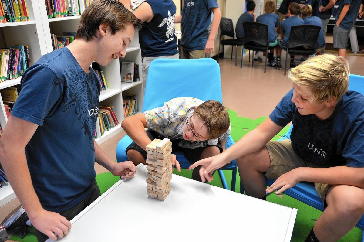 Lions Heart members Gavin Reese, left and Harrison Halperin, right, play Jenga with Zeke Eampietro, during a day of activities at the Down Syndrome Foundation Center on Sunday.